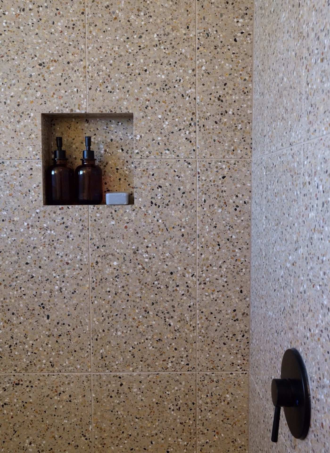 a bathroom with a terrazzo tiled shower.