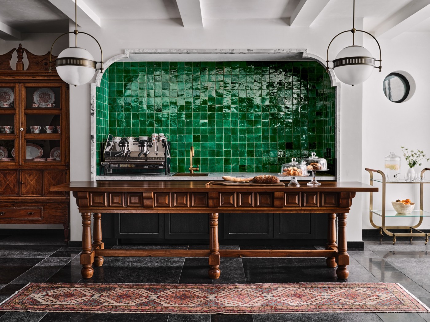 a kitchen with a green tiled wall.