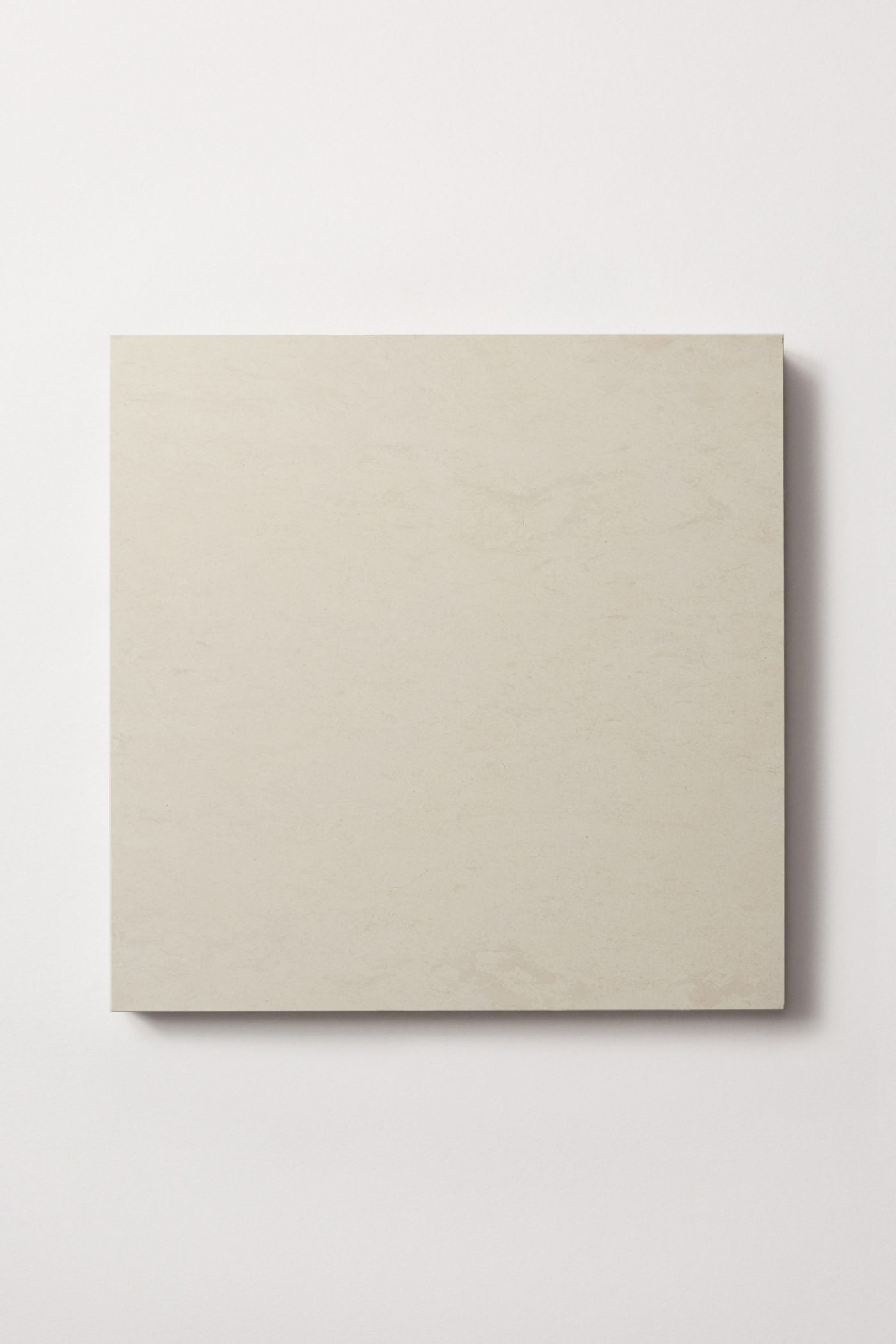 A single off white colored limestone tile centered on a white background. Grand Place collection in Tabor, from clÃ© Tile.