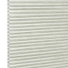 Pale green honeycomb (cellular) blind, fully lowered with visible hexagonal cells and textured fabric; closed, gently diffusing daylight; fills the frame against a bright neutral background suggesting an interior window.