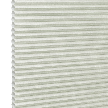 Pale green honeycomb (cellular) blind, fully lowered with visible hexagonal cells and textured fabric; closed, gently diffusing daylight; fills the frame against a bright neutral background suggesting an interior window.