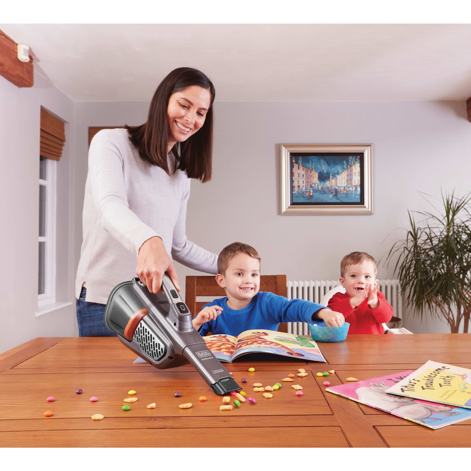 Dustbuster advanced clean plus cordless hand vacuum with powered pet head being used by a person to clean table.\n