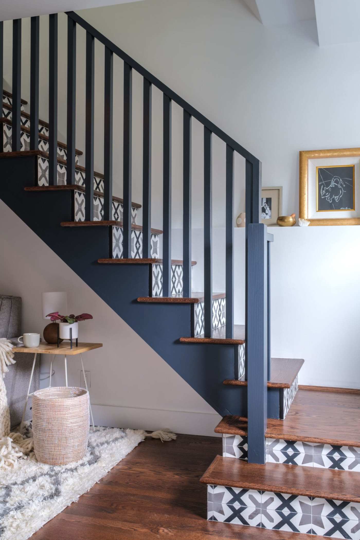 a black and white tiled staircase with railing in a living room.