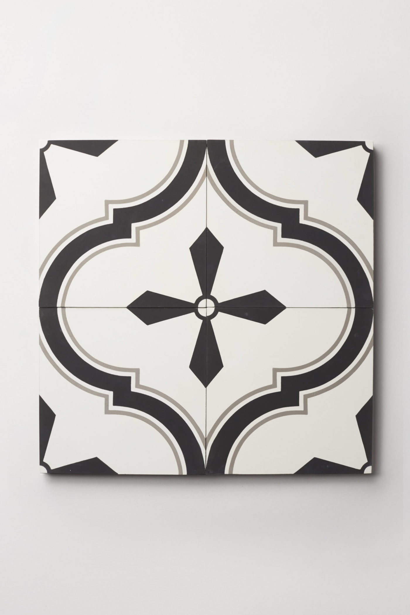 four black and white tiles forming a pattern on a white surface.