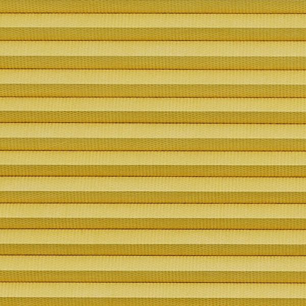 Horizontal cellular (honeycomb) pleated blind, closed with evenly spaced golden-yellow fabric folds and subtle texture; blocking light and insulating, filling the frame under warm diffuse lighting.