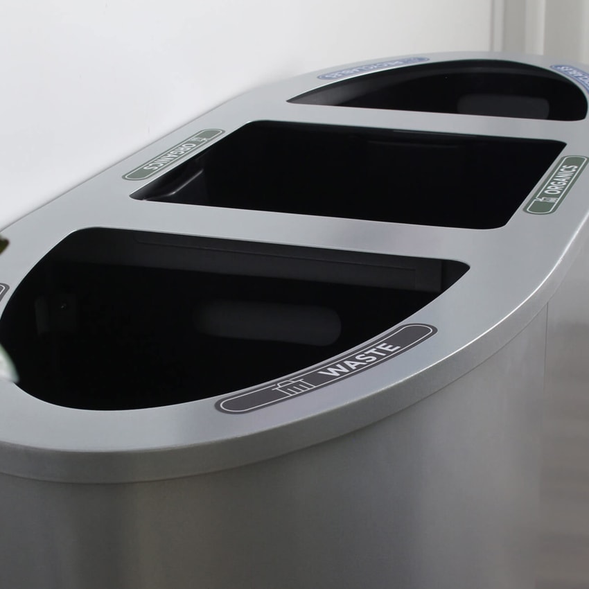 closeup of a triple opening trash and mixed recycling container showing the labels