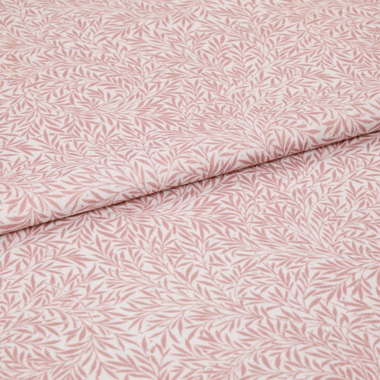 Pink-and-white patterned fabric (leaf print) folded in half and overlapping; close-up flat lay on a neutral surface with soft, even lighting, highlighting woven texture and repeating botanical motif.