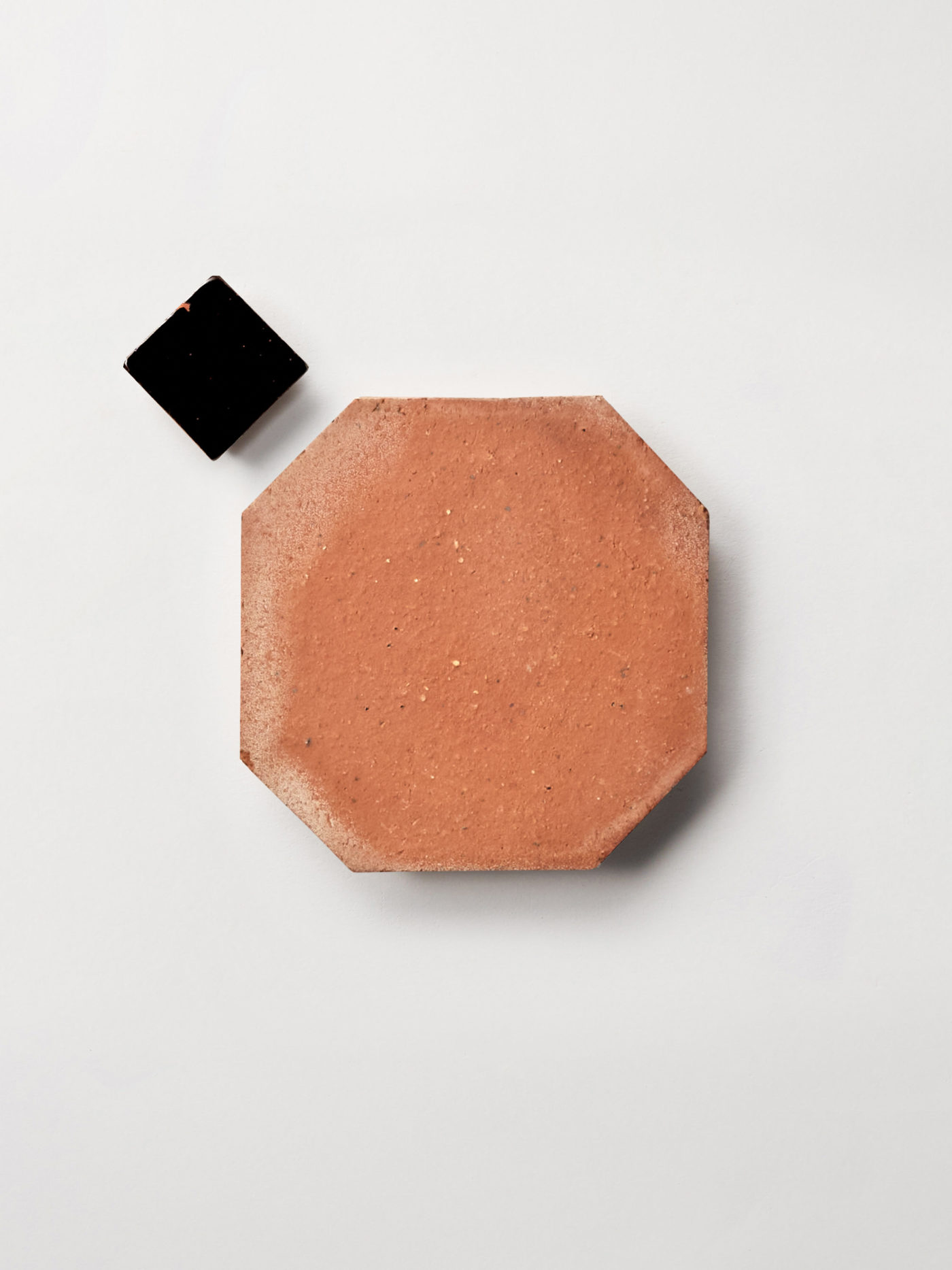 terracotta and black tiles on a white surface.