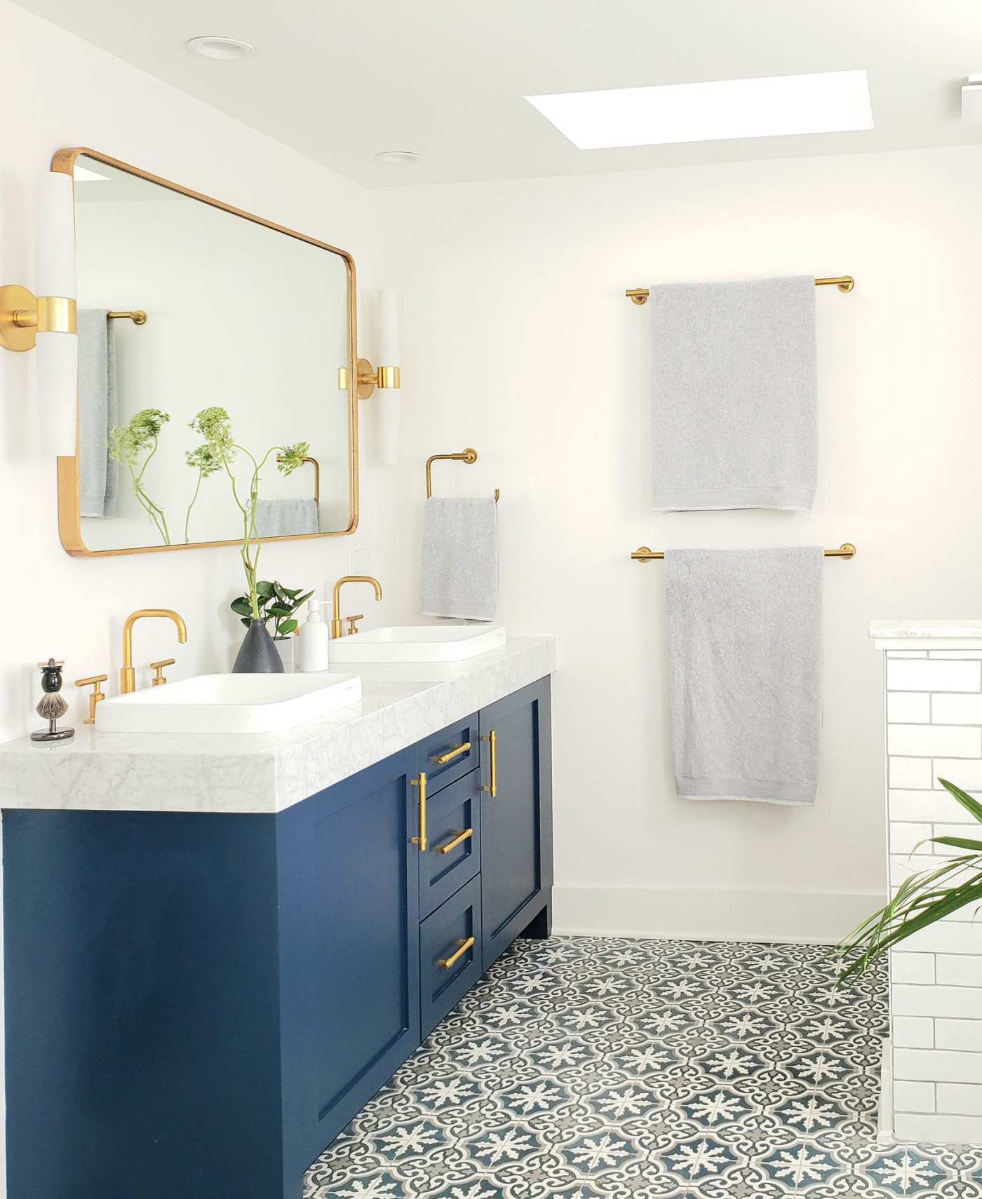 a blue and gold bathroom with a large mirror.