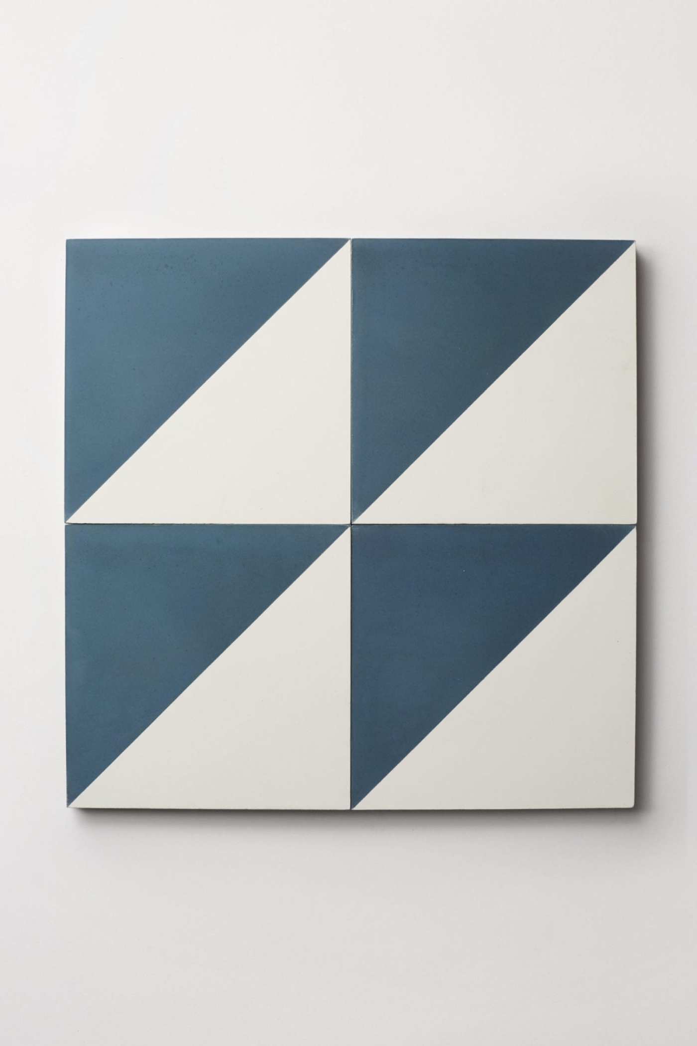 four blue and white tiles on a white surface.