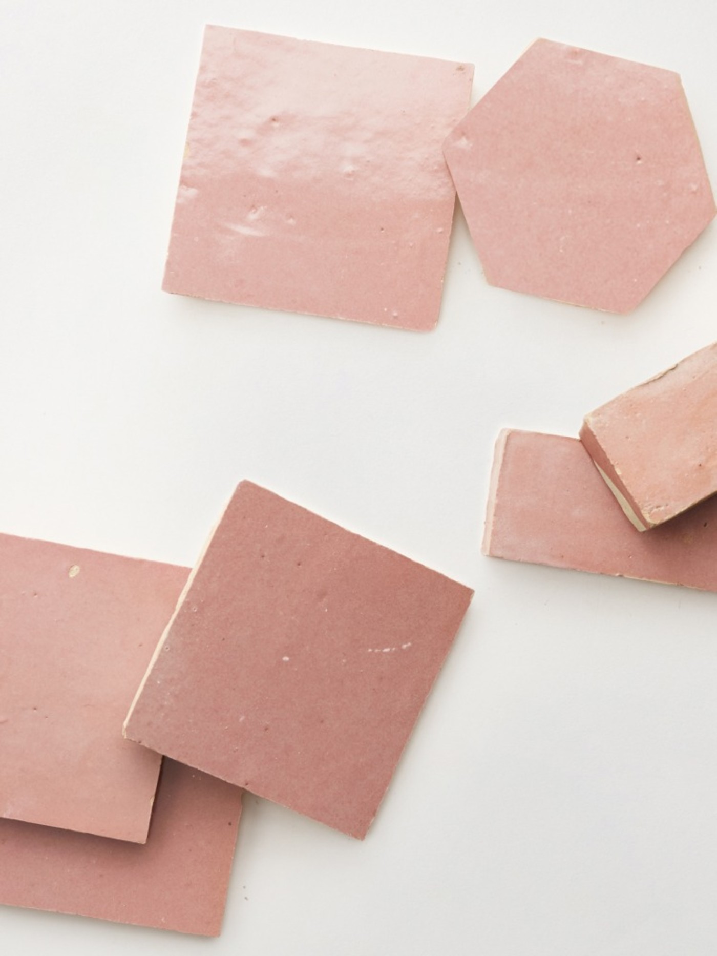 a group of pink tiles laid out on a white surface.