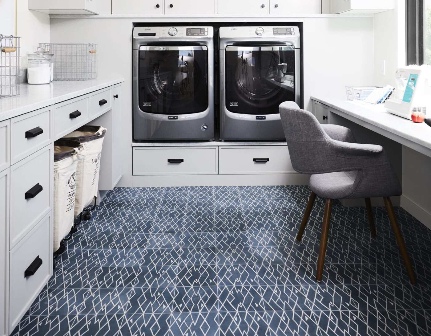 a laundry room with a washer and dryer and blue patterned tile floors.