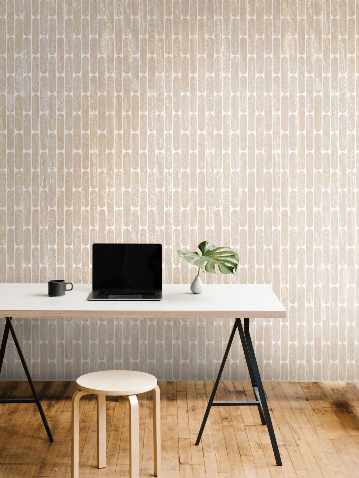 a laptop on a desk in front of a tiled wall.