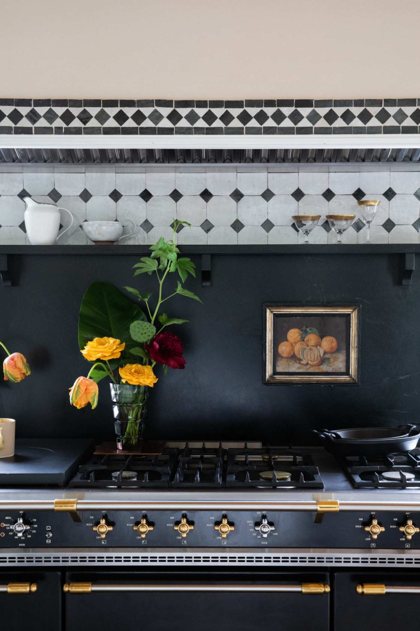 a black and gold stove with flowers in a vase on the stove.