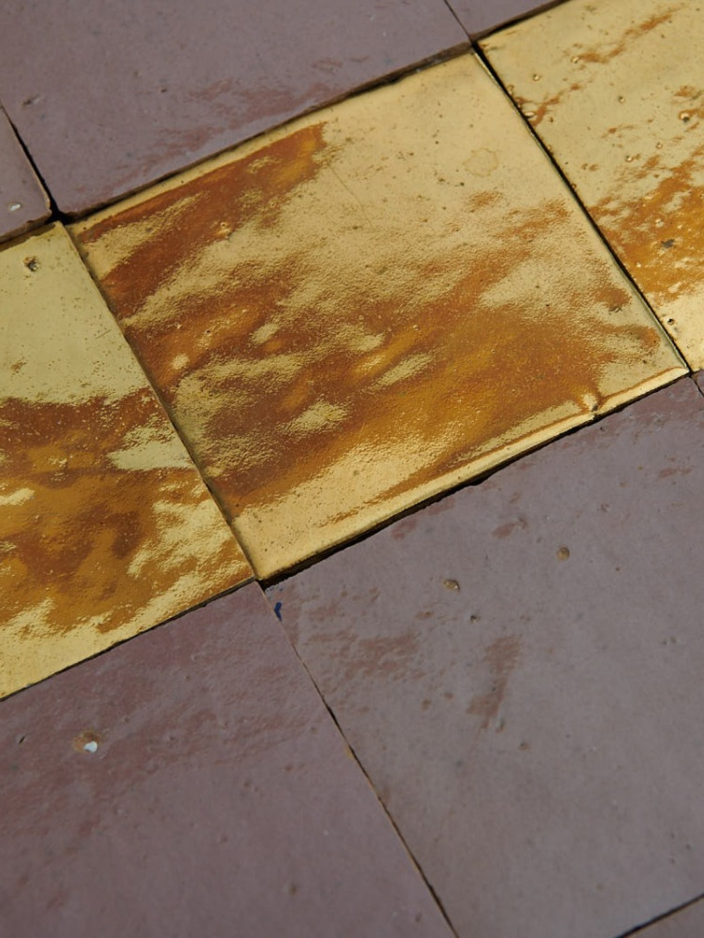 a row of gold tiles between rows of grey tiles.