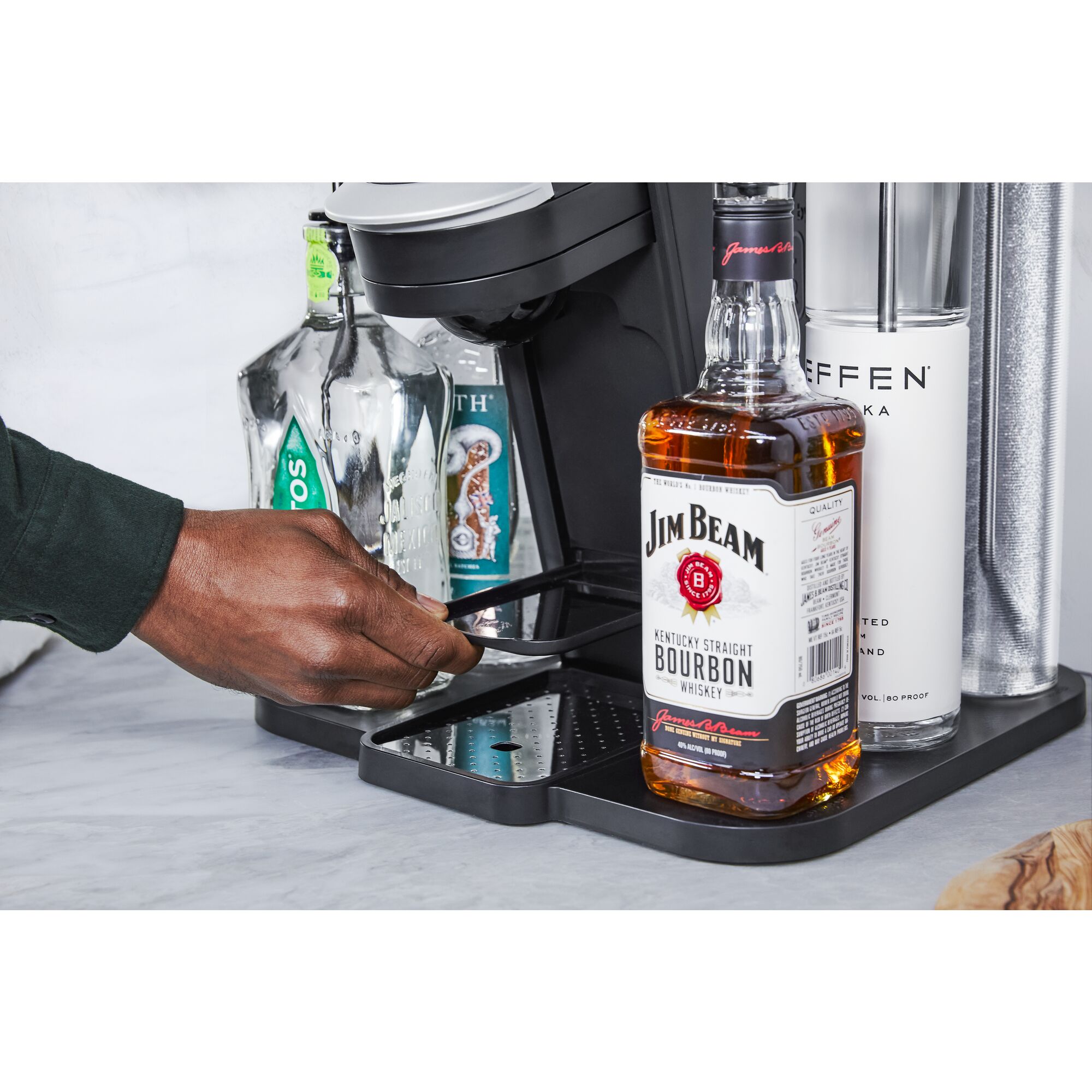 close-up, in the kitchen, on the patio, of a man locking a bottle of whiskey into the easy load liquor system on the bev by BLACK+DECKER™ cocktail maker