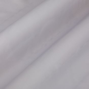 Pale lavender curtain fabric, hanging in soft diagonal folds, gently diffusing light in a neutral, dim interior close-up.