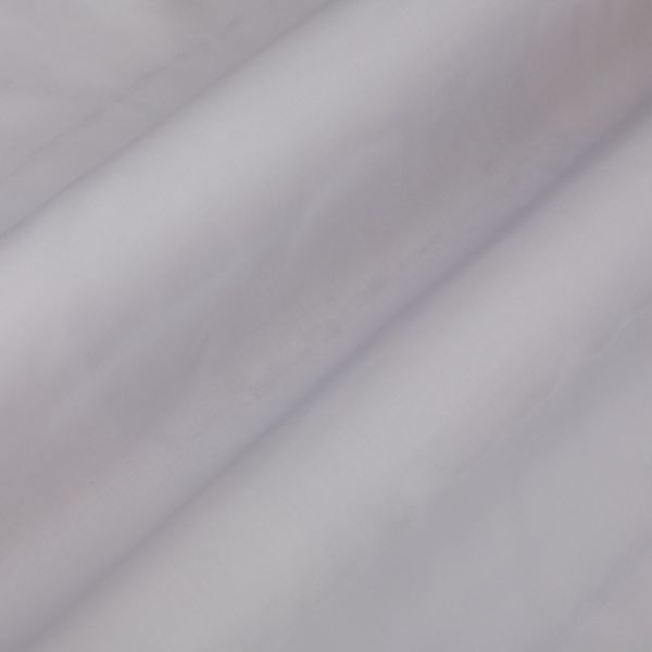 Pale lavender curtain fabric, hanging in soft diagonal folds, gently diffusing light in a neutral, dim interior close-up.