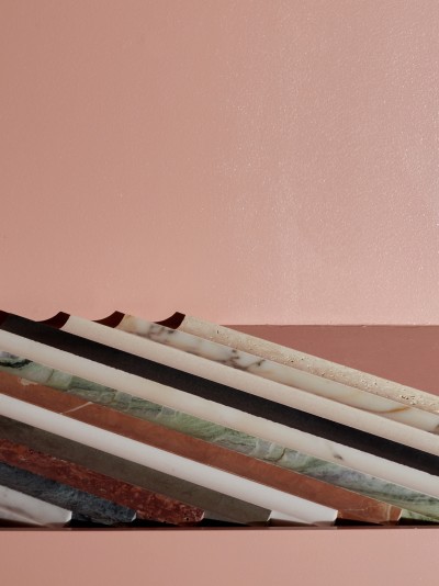 a row of marble pencils on a pink surface.