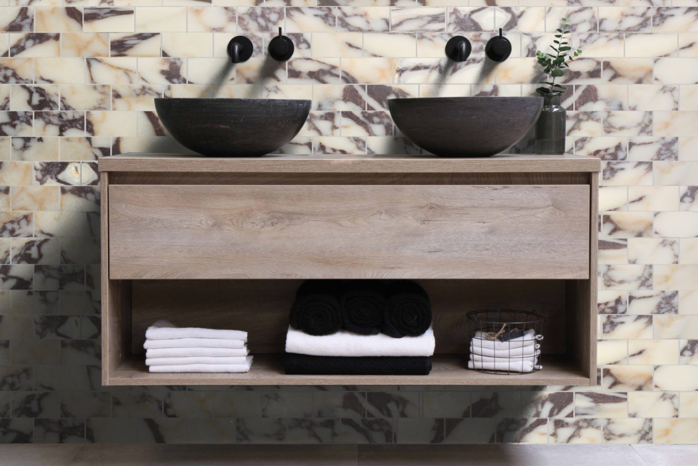 a bathroom with two sinks and a marble wall.