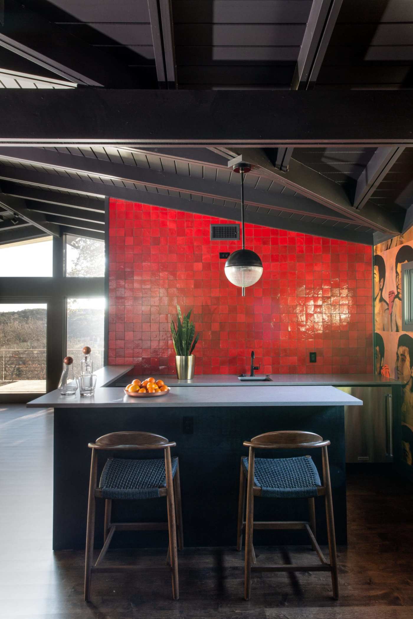 a kitchen with a red tiled wall.