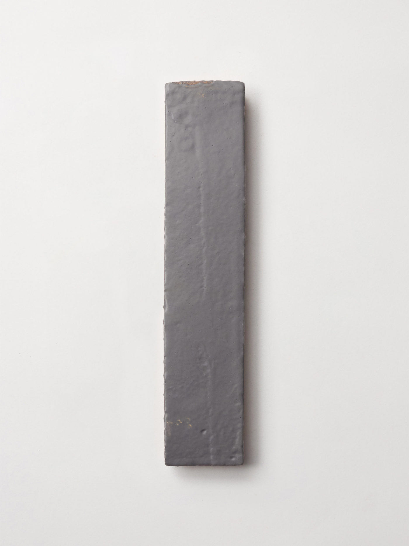 a grey tile on a white wall.