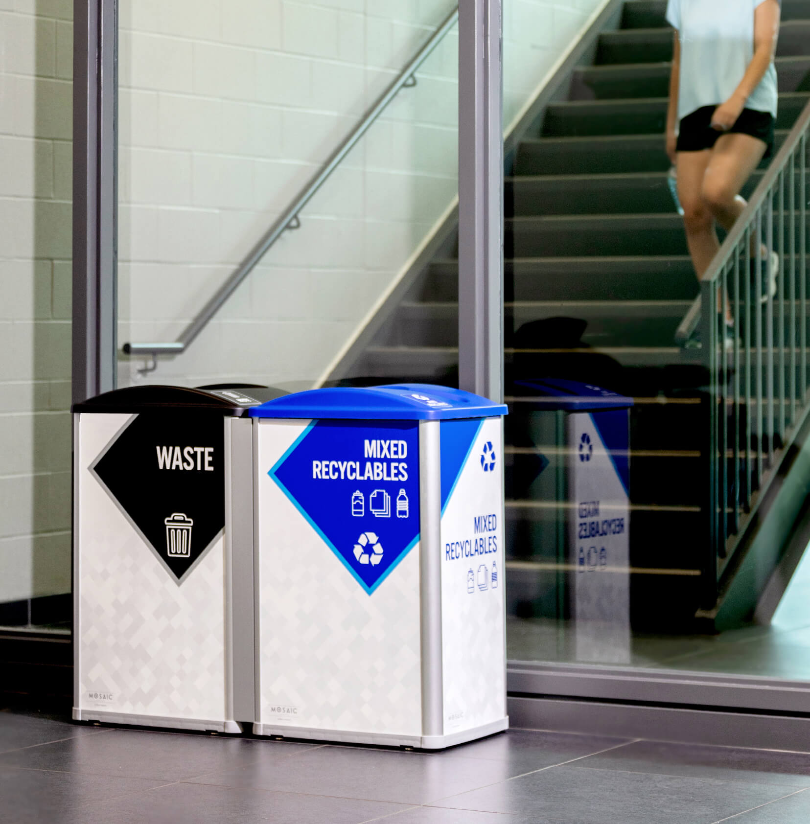 a double waste and mixed recyclables station inside a high school with large signs that show collection details