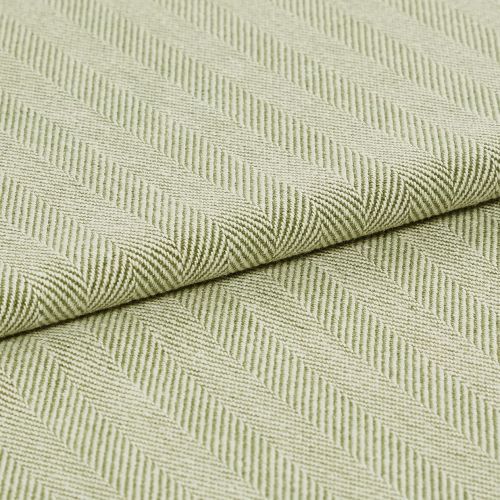 Pale green woven fabric with raised diagonal ribbed herringbone pattern, folded across the frame; the fabric displays pronounced texture and ridges under soft, even studio lighting in a close-up view.