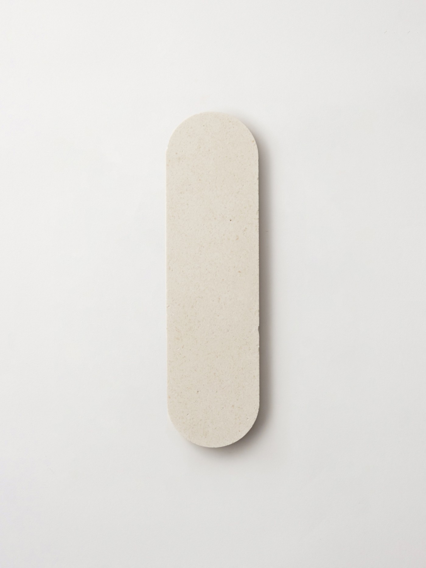 a white oval tile on a white surface.