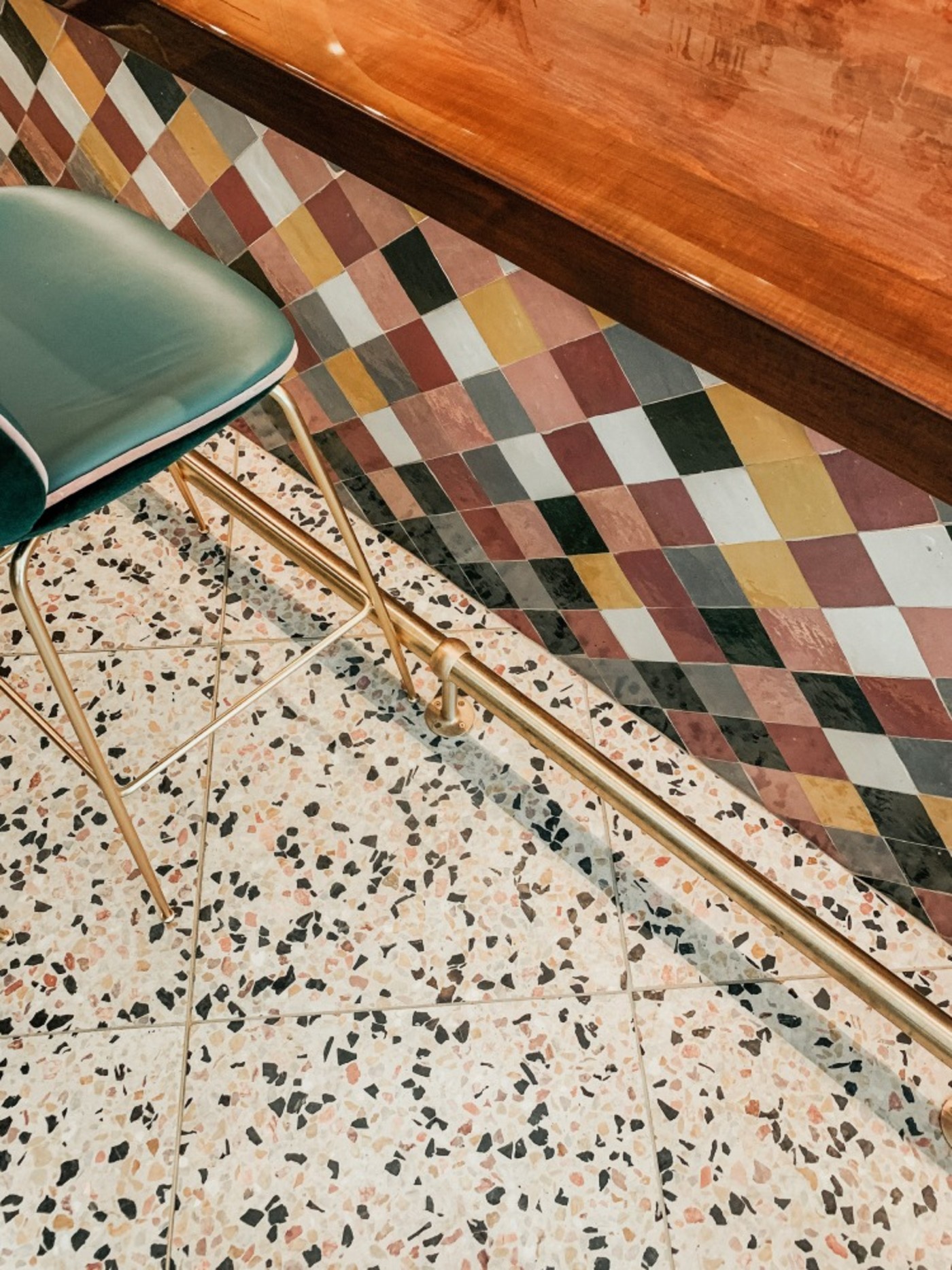 a green chair sits in front of a tiled wall.