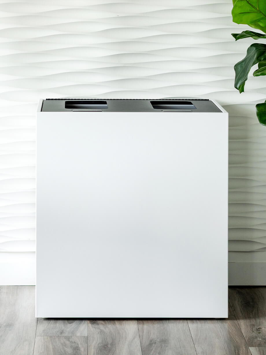 white powder coated steel waste and recycling bin with a black hinged lid in a modern office meeting room
