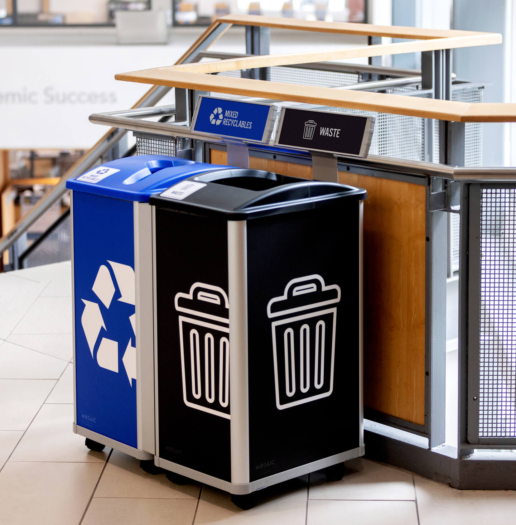 waste and recycling containers in a college library with casters and large signage