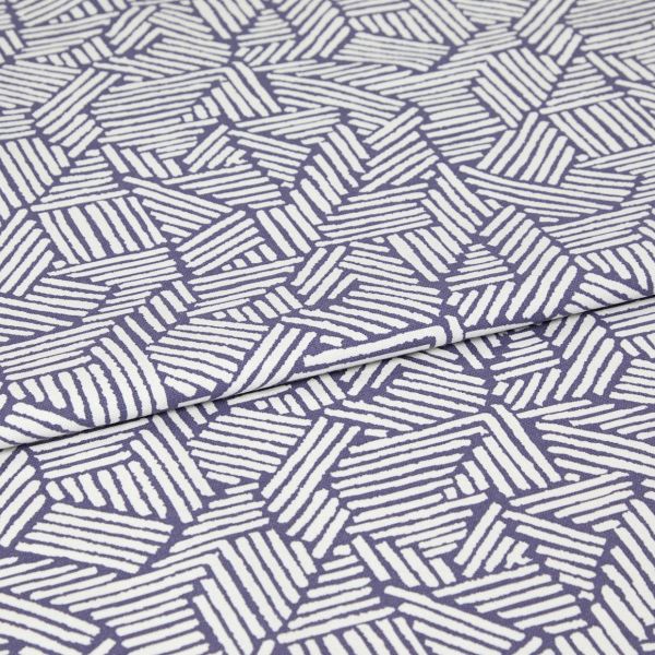 Folded fabric with purple background and white hand-drawn diagonal stripe hexagon pattern; the cloth is folded once with a visible overlap; close-up on a flat surface under even studio lighting.