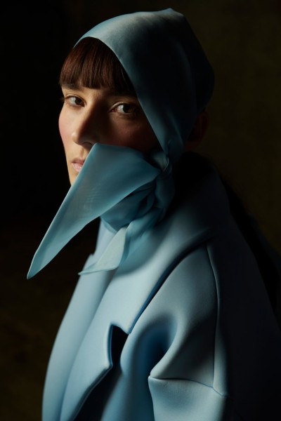 a woman in a blue coat with a scarf.