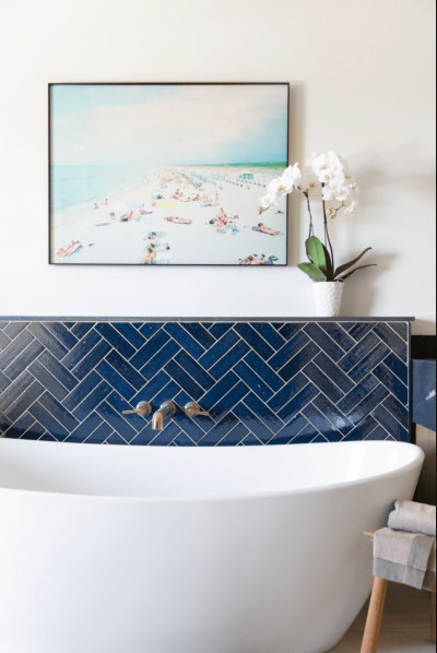 a bathroom with a blue and white tiled wall.