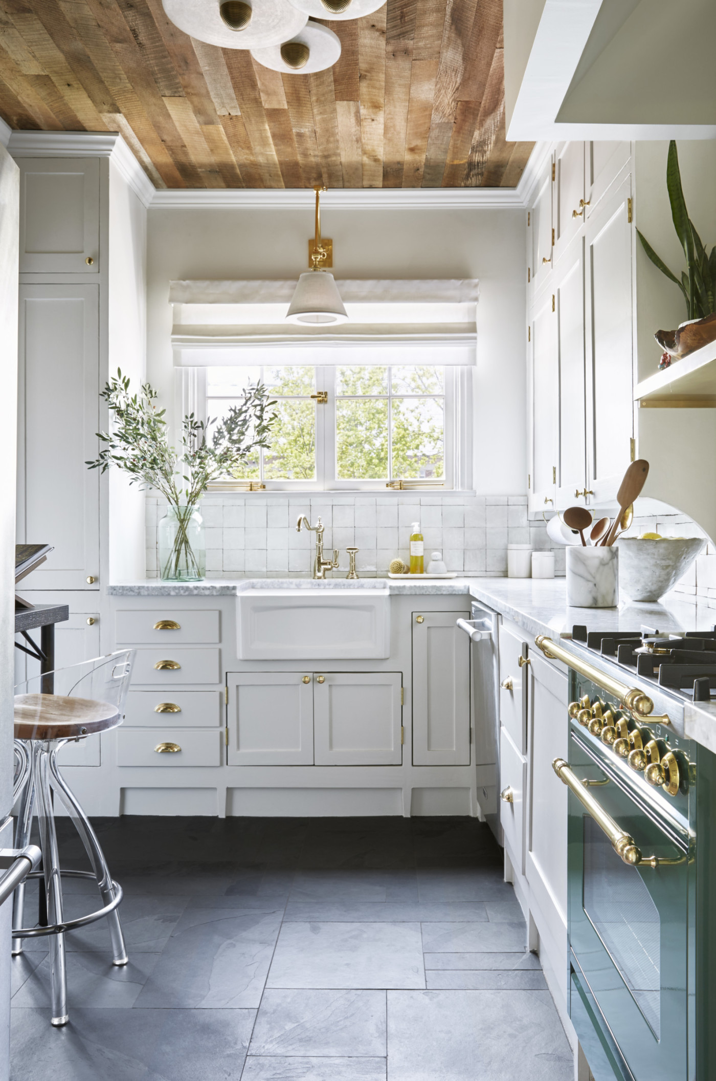 a white kitchen with a wooden ceiling.