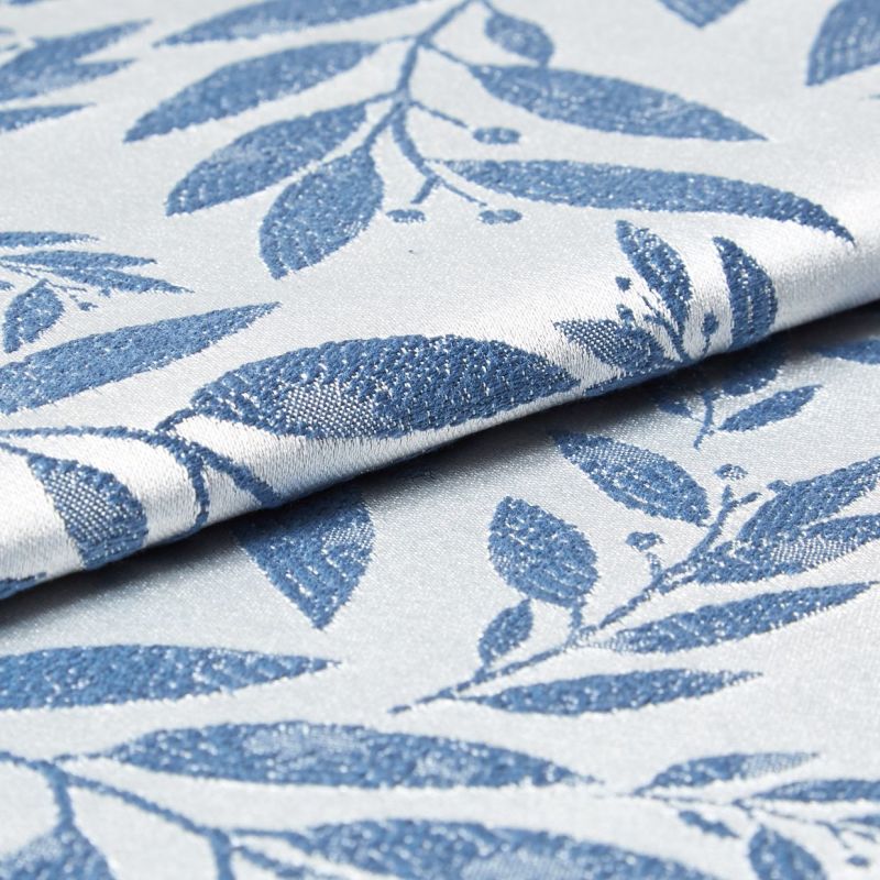Folded woven fabric with raised blue leaf jacquard pattern; folded and overlapping, revealing textured weave and subtle sheen; close-up product-style shot with soft, neutral lighting suggesting upholstery or curtain material.