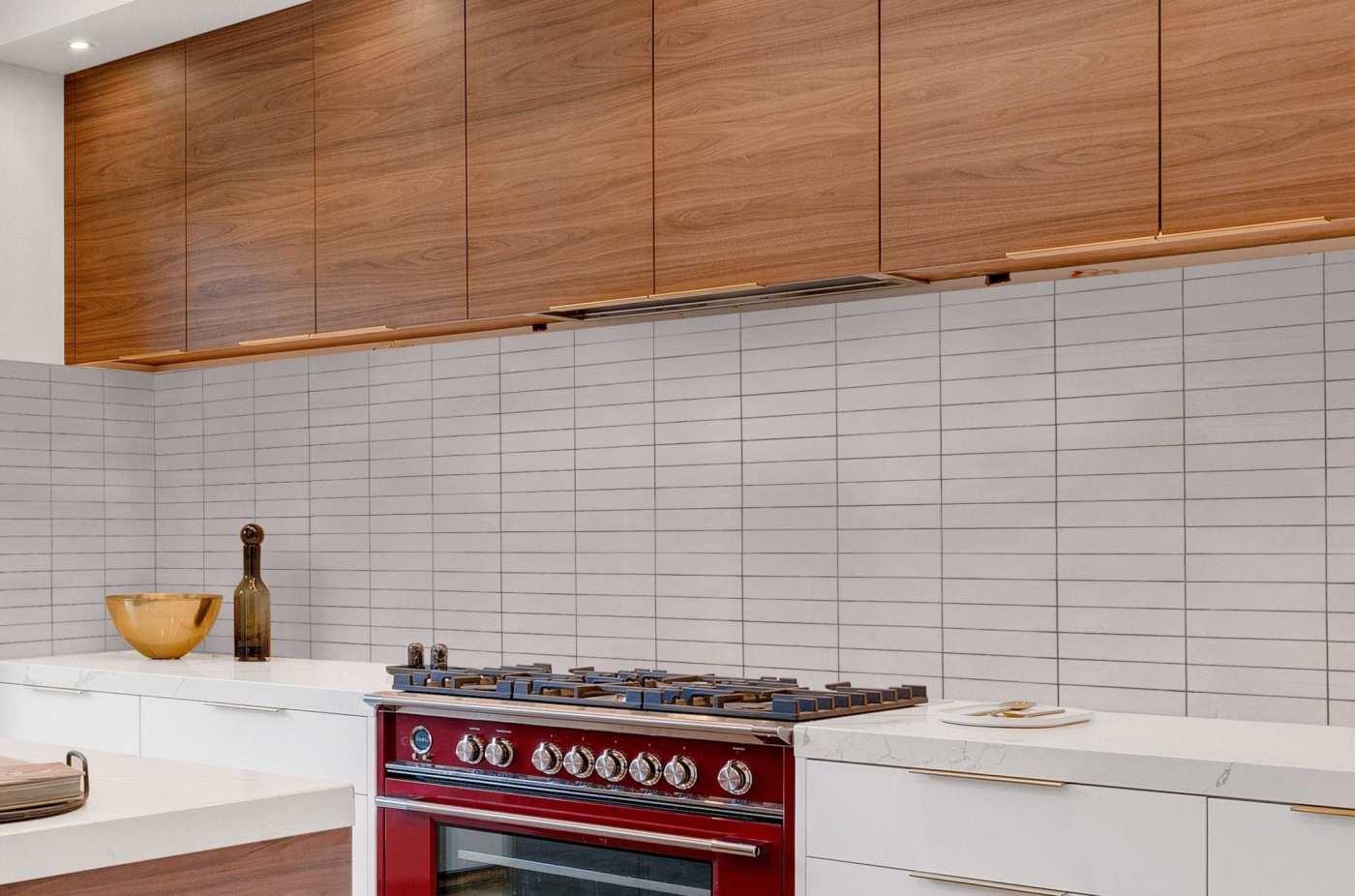 a kitchen with white counters, a red oven and wooden cabinets.