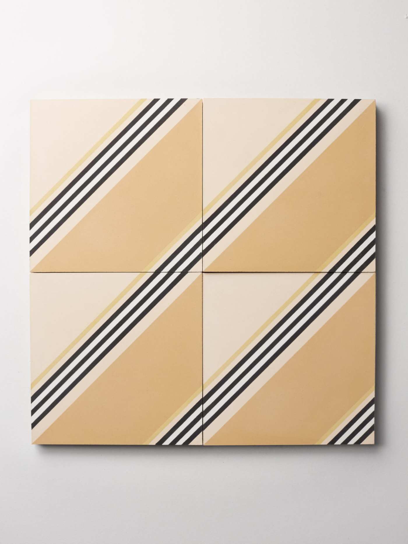 four yellow and beige tiles with black and white stripes on them.