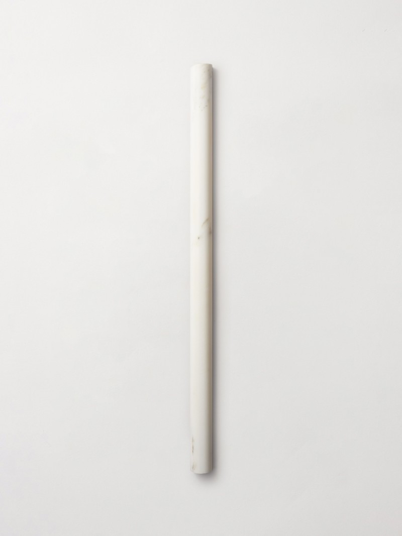 a white marble pencil on a white surface.