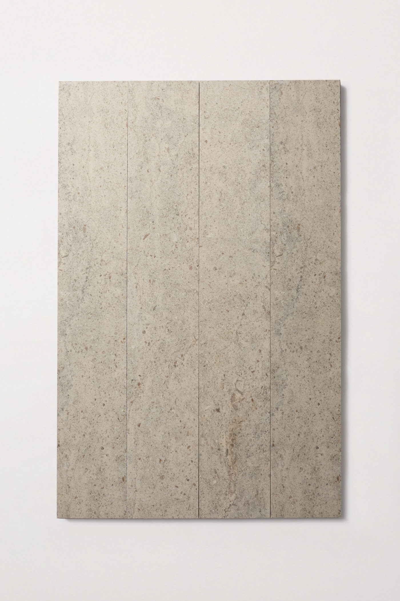 four long rectangular grey limestone tiles on a white surface.