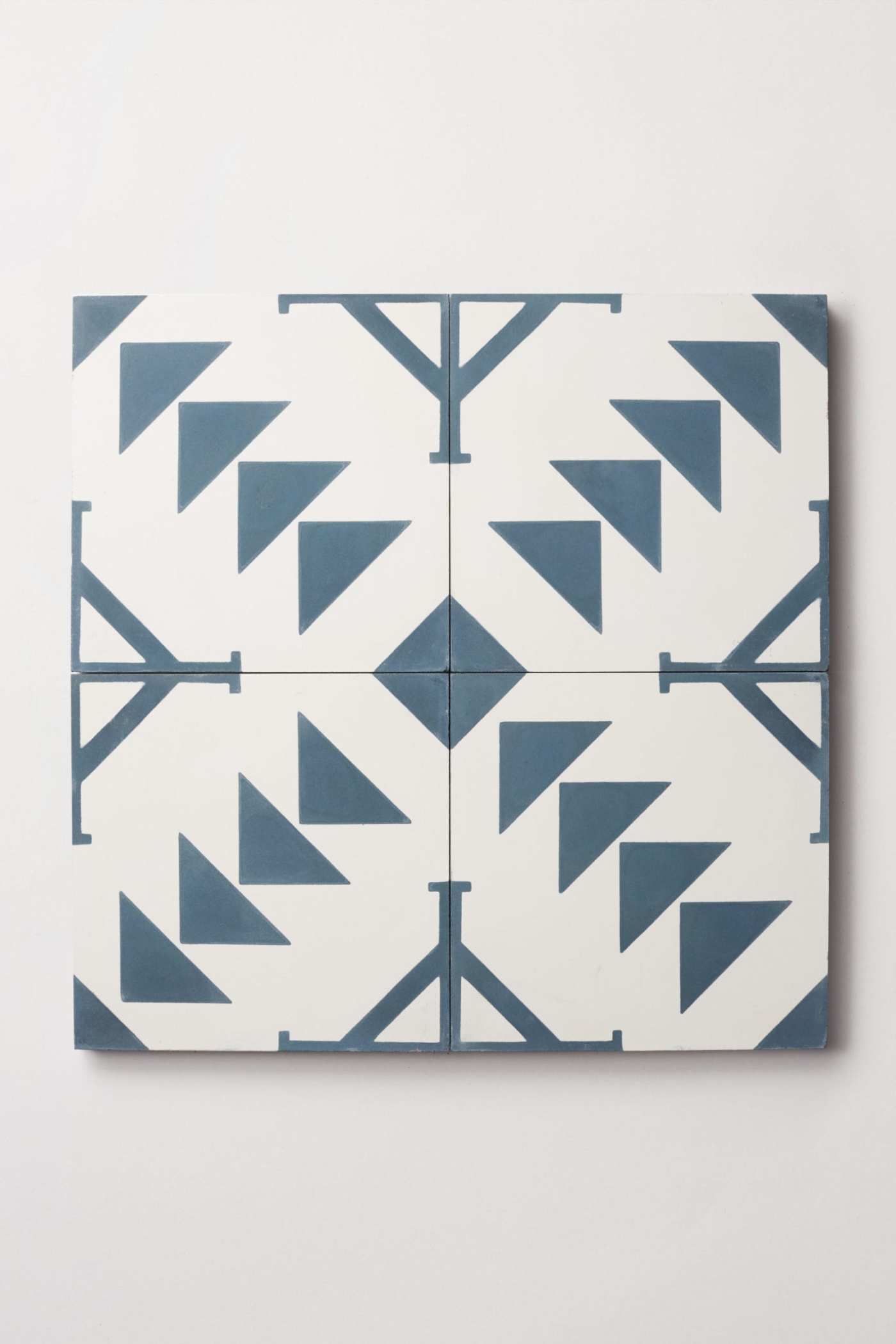 four blue and white tiles with triangles on them.