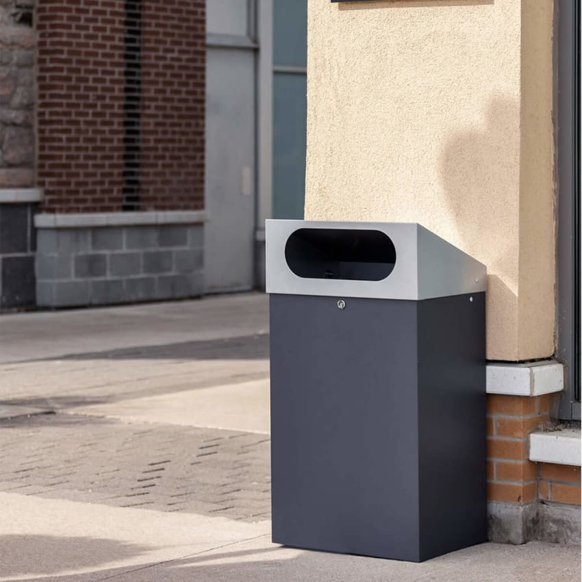 durable powder coated steel outdoor trash bin with locking lid and large waste opening outside a shopping plaza