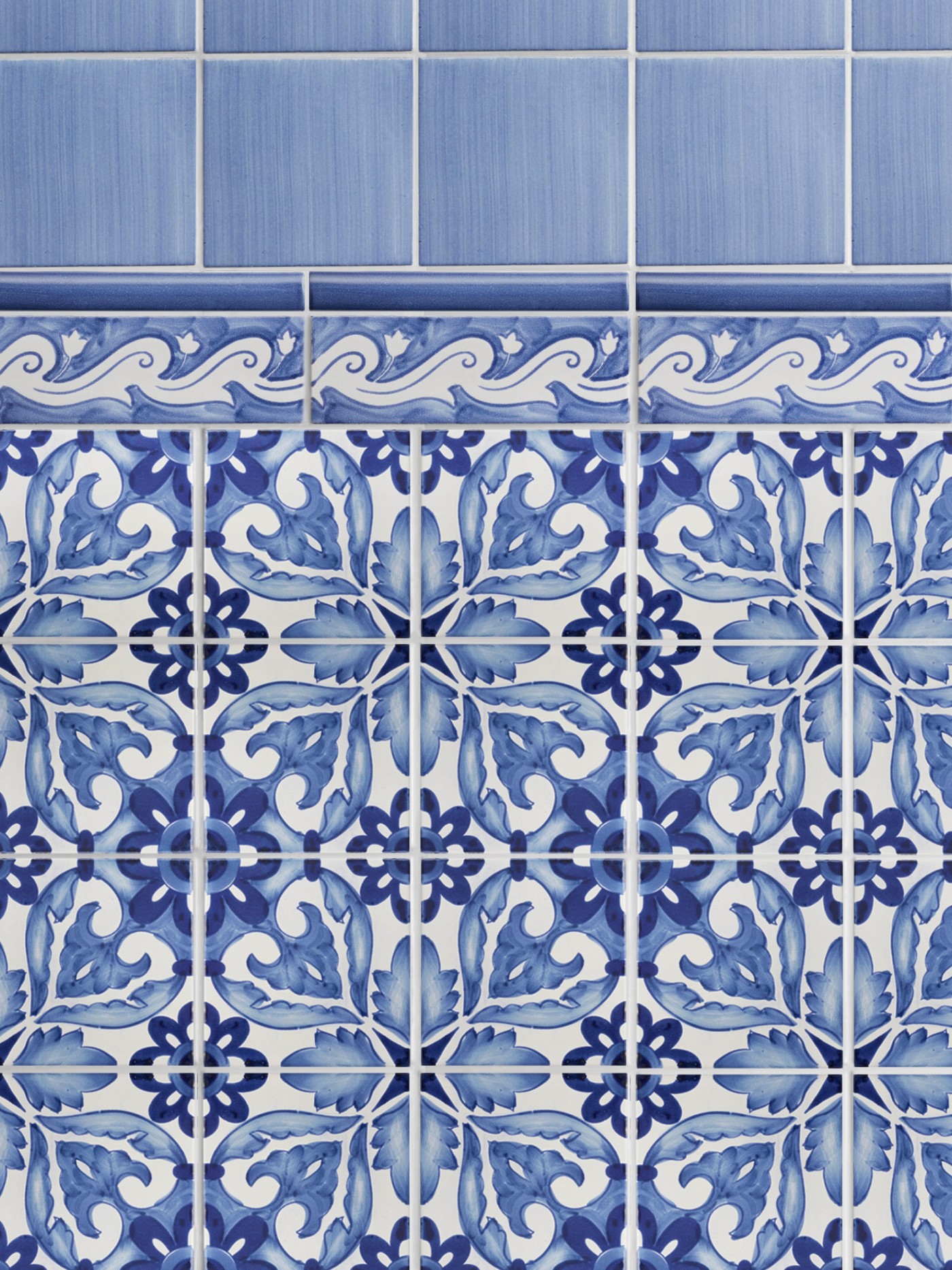 a blue and white tiled wall with a floral design.