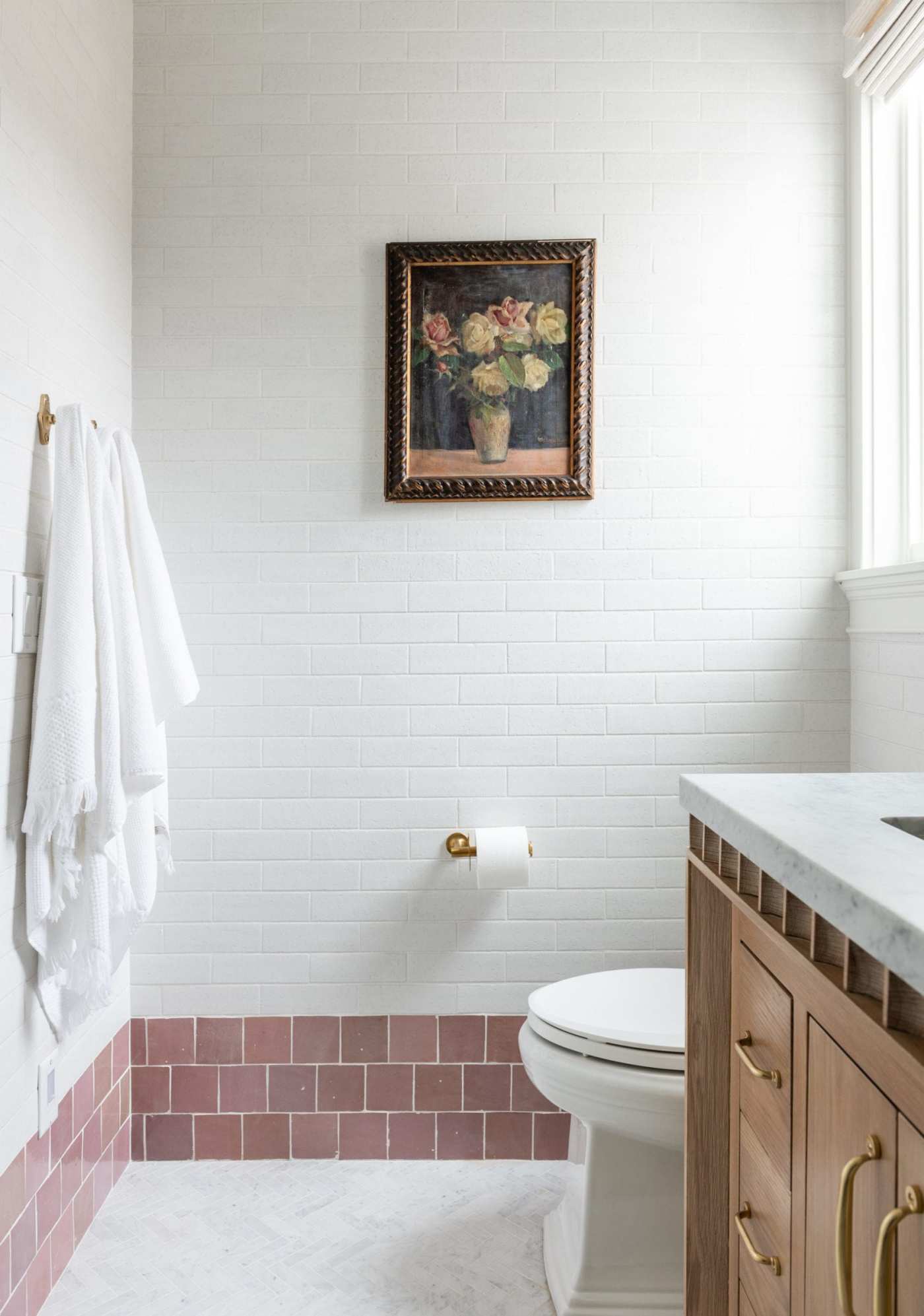 a bathroom with white and pink tile walls.