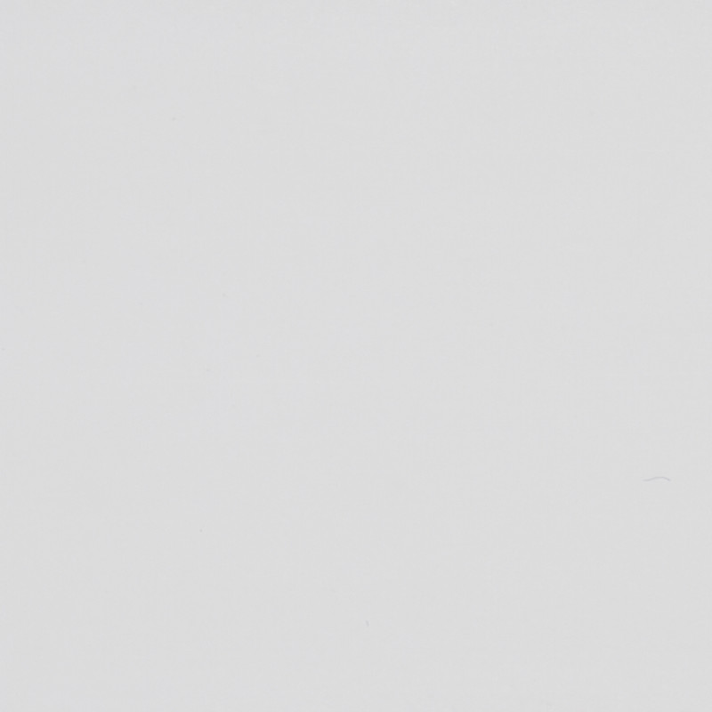 Blank off-white surface shows faint scuffs and tiny specks, evenly lit in a close-up, minimal context with subtle paper- or plaster-like texture.