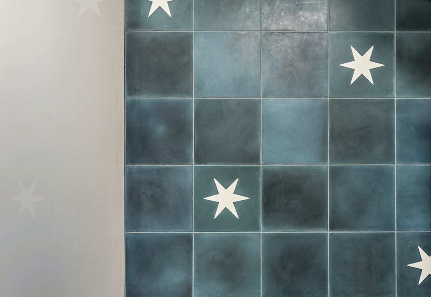 a blue and white tiled wall with stars painted on it.