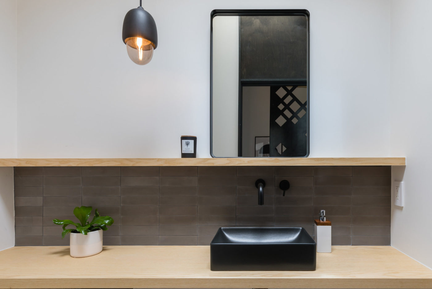 a black sink on a wooden shelf.