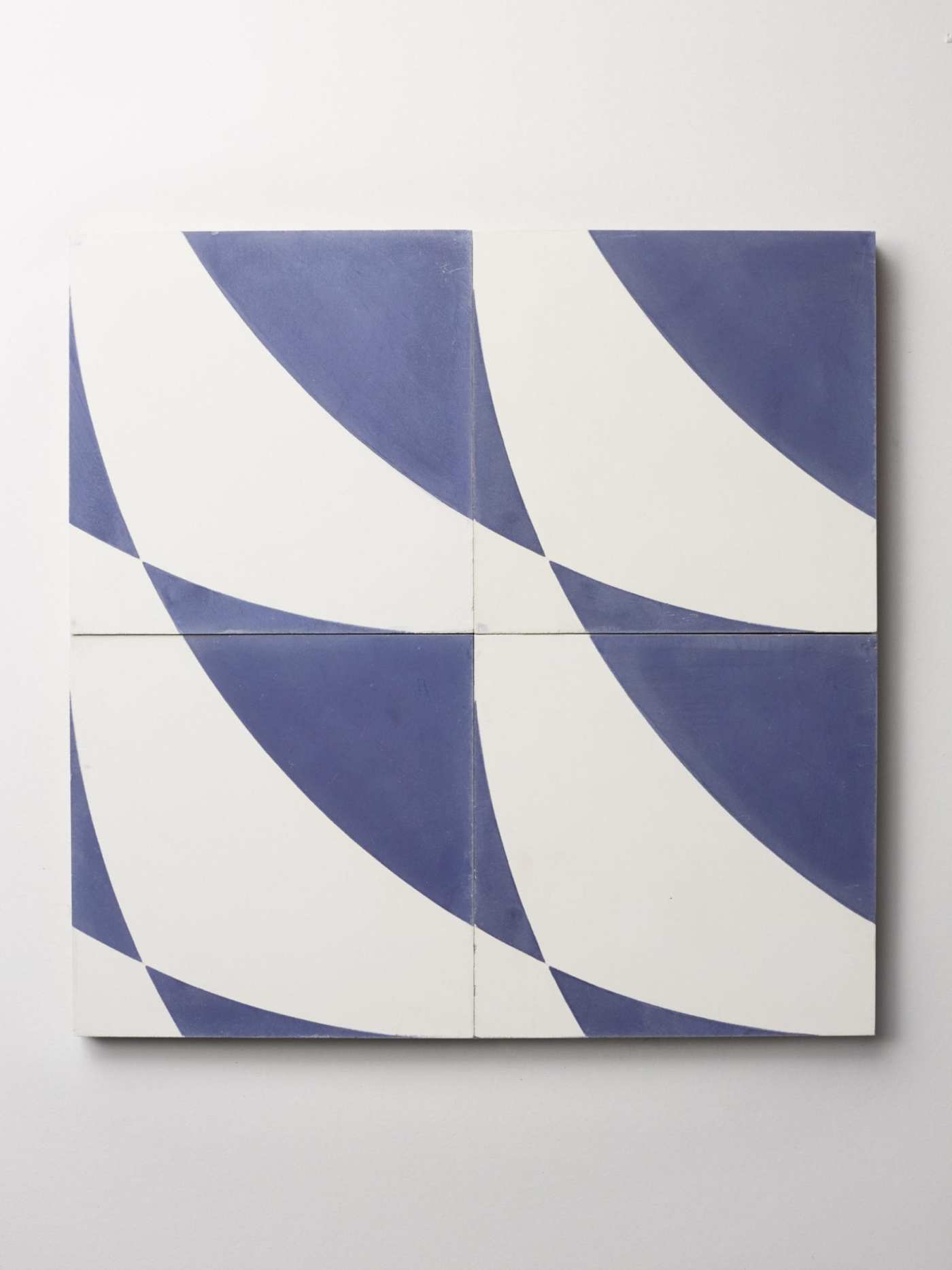 four blue and white tiles on a white surface.