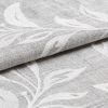 Textured gray fabric with raised white leaf embroidery folded and partially rolled, overlapping; close-up studio-lit view highlighting the weave and embossed botanical pattern.